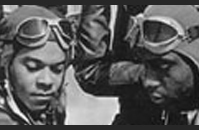Pilots gathered around a plane at the Tuskegee Airfield.
