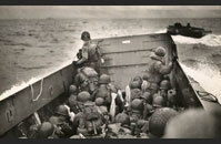 LCVP Utah - Tightly packed troops crouch inside their LCVP as it plows through a wave. In the distance is the coast of Normandy.