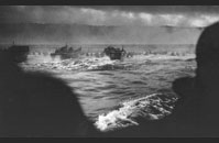 Omaha Beach - LCVPs (Landing Craft Vehicle, Personnel), or Higgins boats, head for Omaha Beach. Landing began at 6:30 am Men can be seen wading ashore; their initial objective, the bluffs above the beach. Image courtesy of National Archives, 26-G-2337